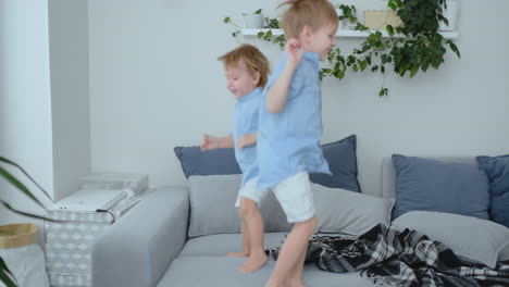 Two-little-boys-jumping-on-the-couch-and-having-fun